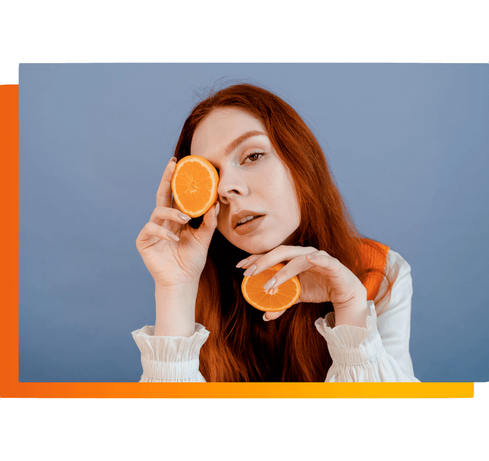 Photo d'accueil d'une assurance santé collective, femme rousse qui tient deux oranges dans ses mains